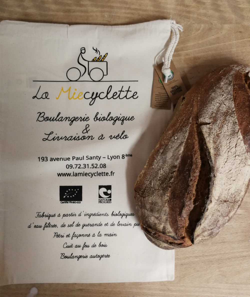 Chers clients, Nous espérons que vous prenez du plaisir à chaque tranche de notre pain au levain. Vous le savez déjà, il est bio, pétri à la main, cuit au four à bois et livré à vélo. Afin de diminuer notre impact écologique nous ne distribuerons plus systématiquement des sachets papiers, pensez à ramener des sacs pour y glisser votre pain. A terme, avec votre soutien, nous visons à supprimer complètement les sachets neufs. Pour les oublis, nous mettons à votre disposition un stock de sachets "autogérés" et vendons des sacs en tissus sérigraphiés localement à la main! « vivre simplement, pour que simplement d’autres puissent vivre » (Gandhi)